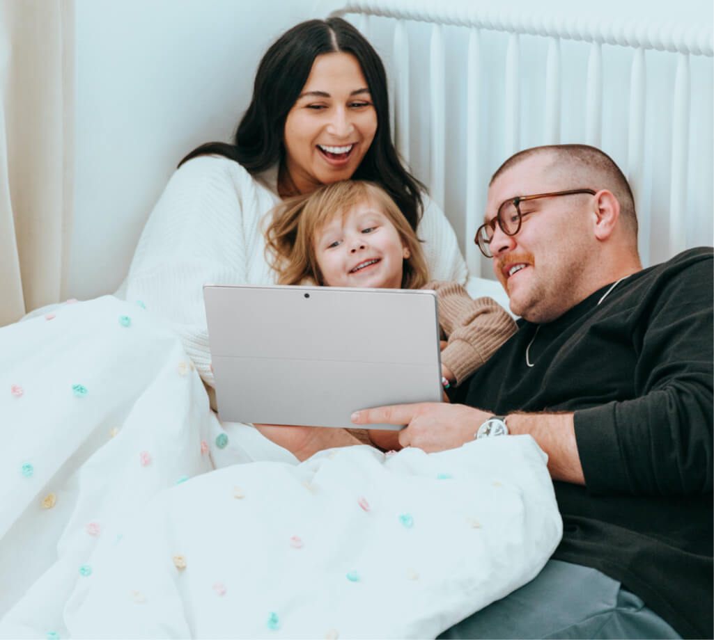 Family watching a tablet in bed - Family dentistry in Thorncreek, CO