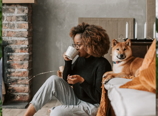 Woman drinking from mug with a dog - Laser Dentistry in Thorncreek, CO