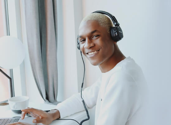 Young man listening to headphones on a laptop - Veneers in Thorncreek, CO
